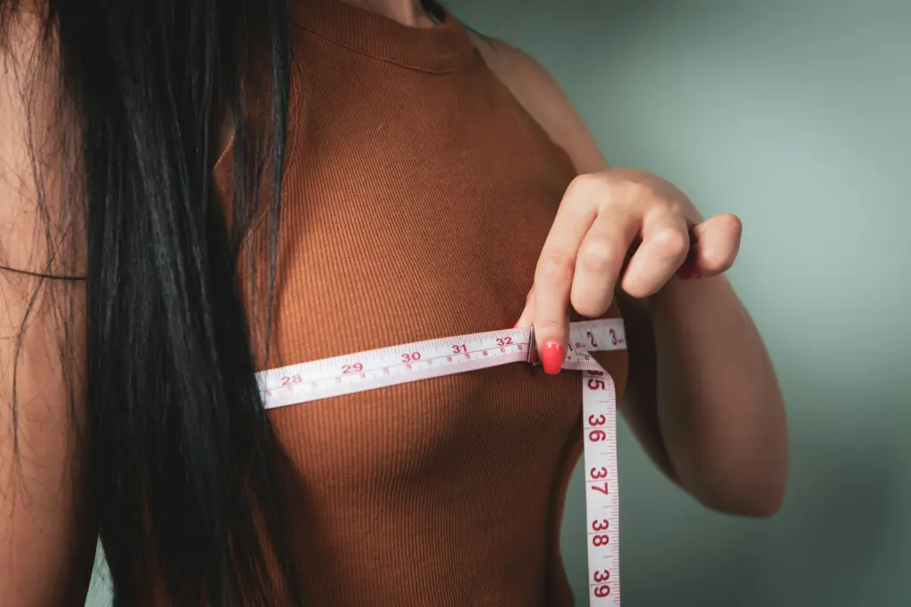 A woman measuring her breasts